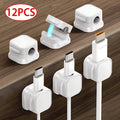 Magnetic cable clips holding charging cables on desk